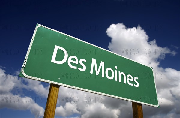 Des moines road sign with dramatic blue sky and clouds