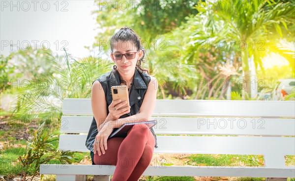 Girl sitting on a bench checking her cell phone