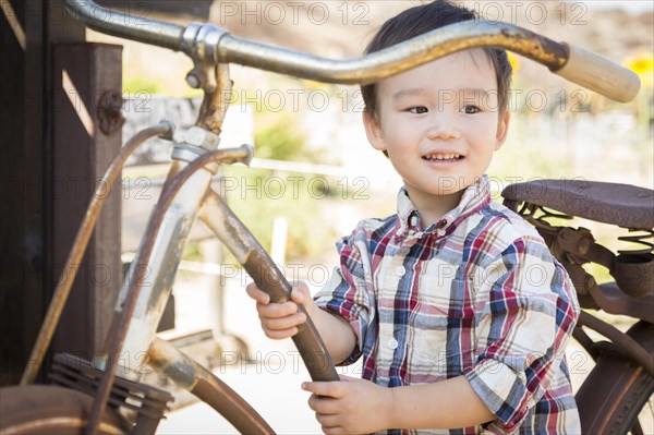 Cute mixed-race young boy having fun on the bicycle