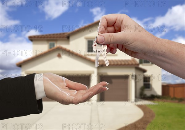 Handing over the house keys in front of a beautiful new home