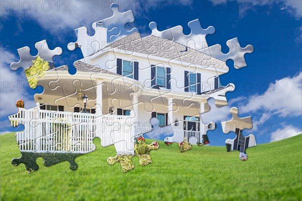 Puzzle pieces fitting together revealing finished house build over grass field