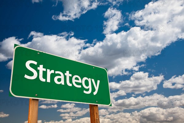 Strategy green road sign with copy room over the dramatic clouds and sky