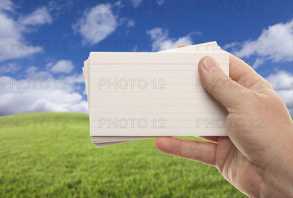 Male hand holding stack of flash cards isolated on a white background