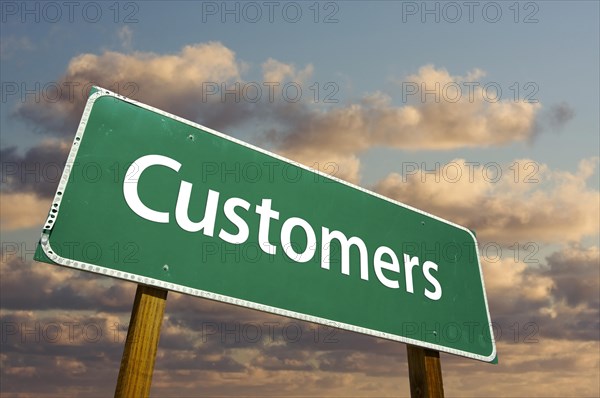 Customers green road sign with dramatic clouds and sky