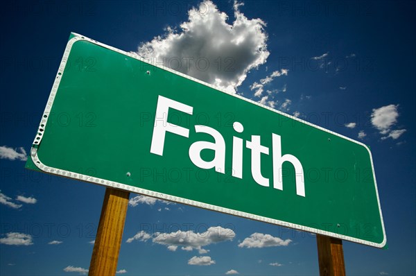 Faith road sign with dramatic clouds and sky