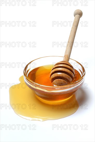 Bee honey with honey spoon in bowl