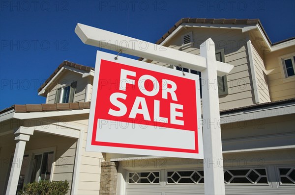 Home for sale sign in front of new house