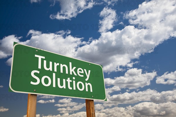 Turnkey solution green road sign with dramatic sky and clouds