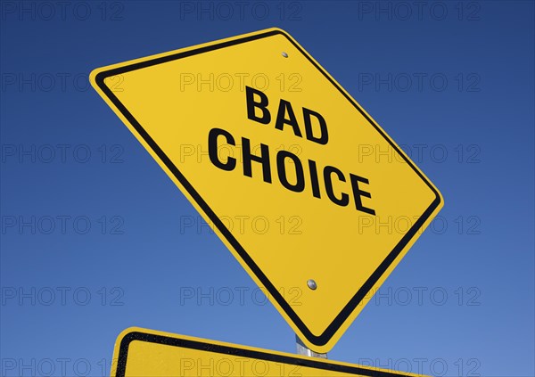 Bad choice yellow road sign against a deep blue sky with clipping path