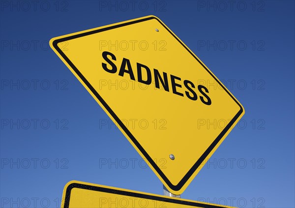 Sadness yellow road sign against a deep blue sky with clipping path