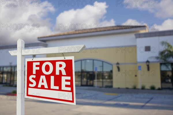 Vacant retail building with for sale real estate sign in front
