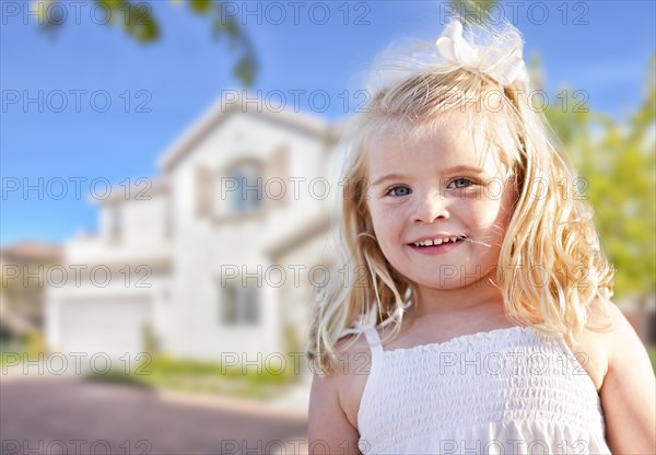 Cute smiling girl playing in front yard of house