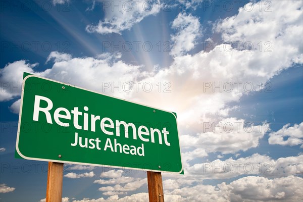 Retirement green road sign with dramatic clouds