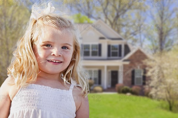 Cute smiling girl playing in front yard of house