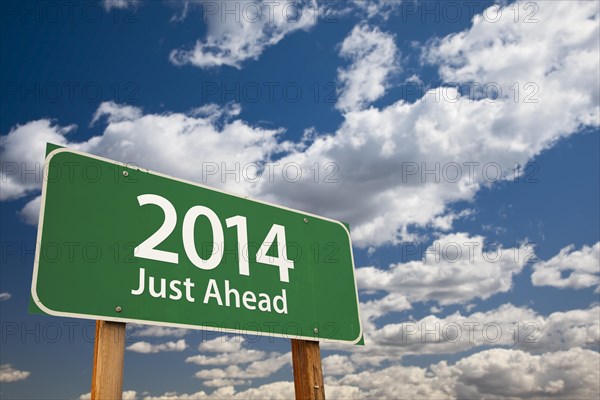 2014 just ahead green road sign over dramatic clouds and sky