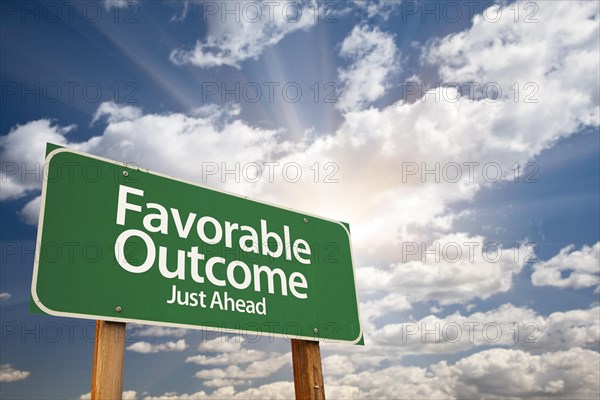 Favorable outcome green road sign with dramatic clouds and sky