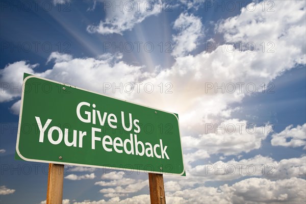 Give us your feedback green road sign with dramatic clouds and sky