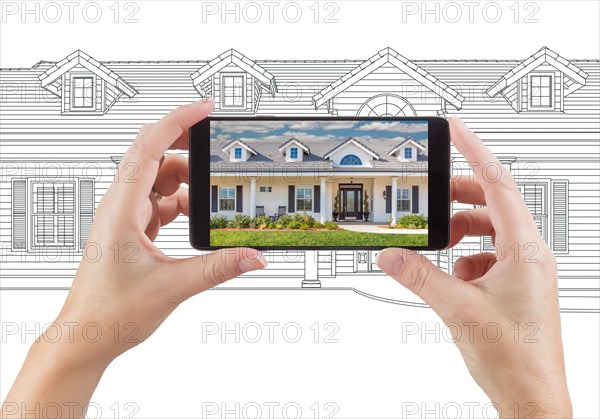 Hands holding smart phone displaying home photo of drawing behind