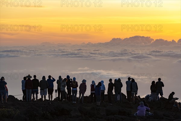 Touristen beobachten den Sonnenuntergang auf dem Gipfel des Haleakala Vulkan