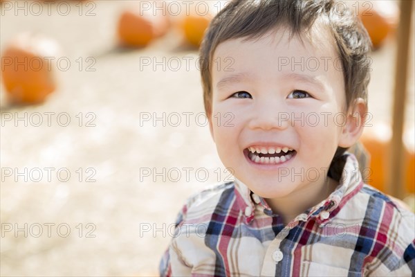 Cute mixed-race young boy having fun at the pumpkin patch