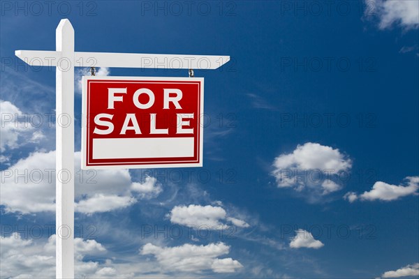 Right facing for sale real estate sign over blue sky and clouds with room for your text