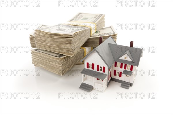 Small house with stacks of hundred dollar bills isolated on a white background
