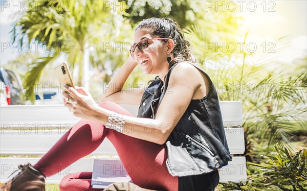 Girl sitting on a bench checking her cell phone