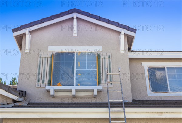 Construction ladder leaning up against A house ready for new paint