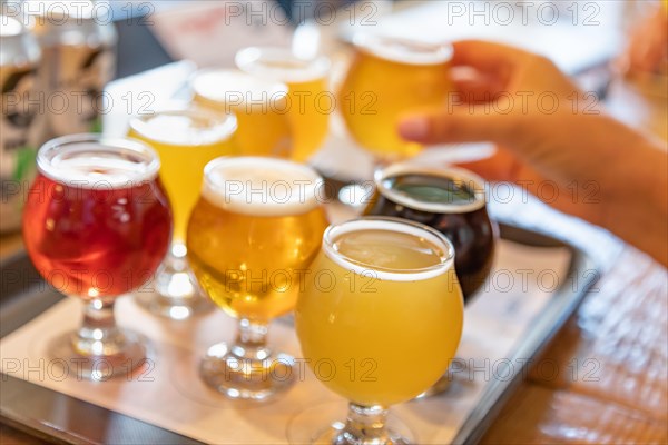 Female hand picking up glass of micro brew beer from variety on tray