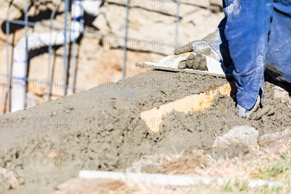 Pool construction worker working with wood float on wet concrete