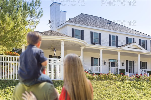 mixed-race young family looking at beautiful new home