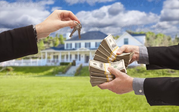 Man handing woman thousands of dollars for keys in front of house