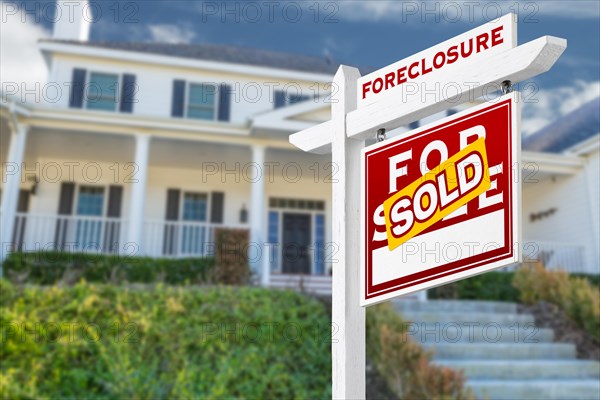 Right facing foreclosure sold for sale real estate sign in front of house