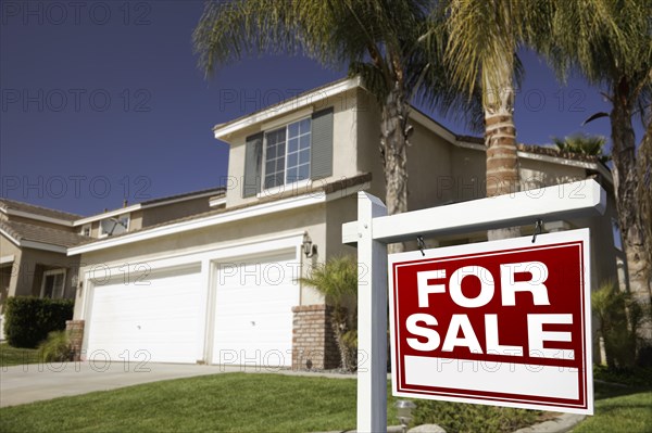 Red for sale real estate sign in front of house