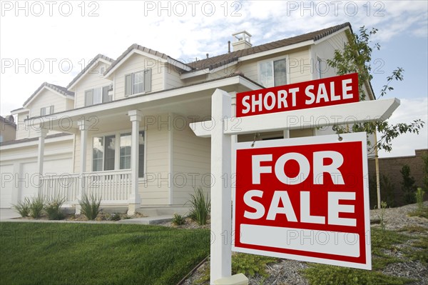 Short sale home for sale real estate sign and house