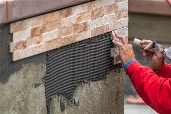 Worker installing wall tile at construction site