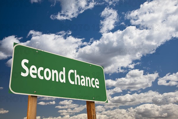 Second chance green road sign over clouds and sky