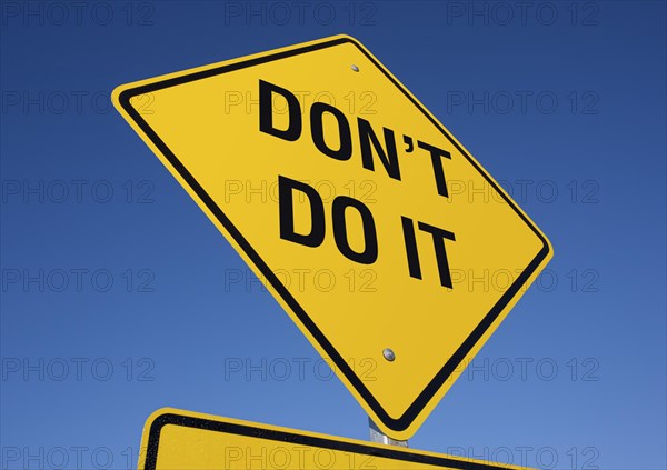 Yellow road sign against a deep blue sky with clipping path