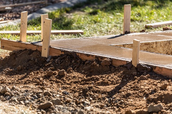 Fresh pool coping cement drying within wood framing