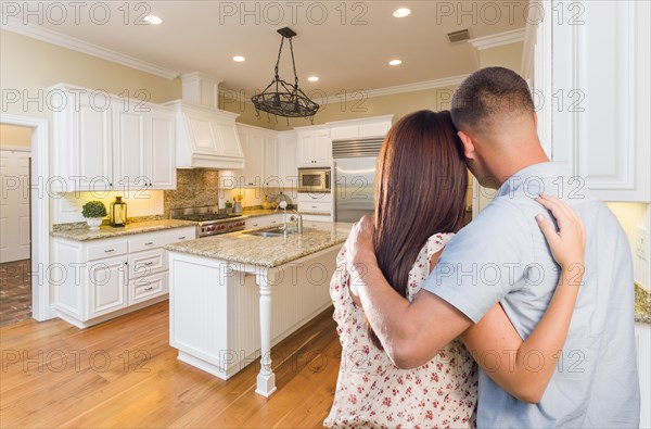 Young hopeful military couple looking at beautiful custom kitchen