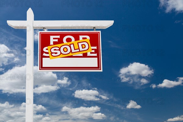 Right facing sold for sale real estate sign over blue sky and clouds with room for your text