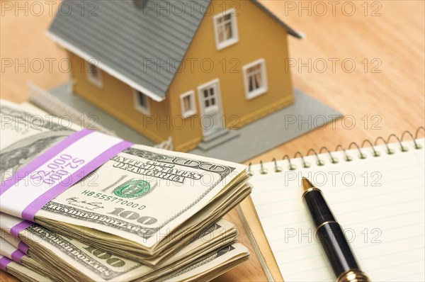 House and money with pad of paper and pen