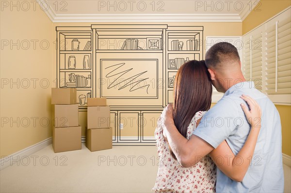 Hugging military couple in empty room with shelf design drawing on wall