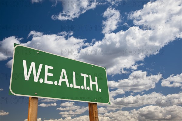 Wealth green road sign and dramatic clouds background