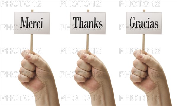 Three signs in male fists saying merci