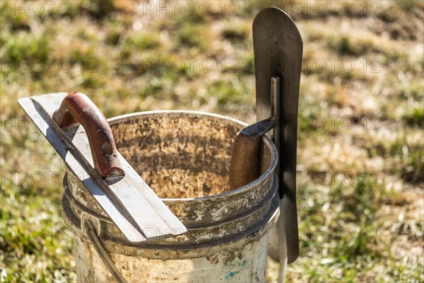 Bucket and cement trowels at construction site