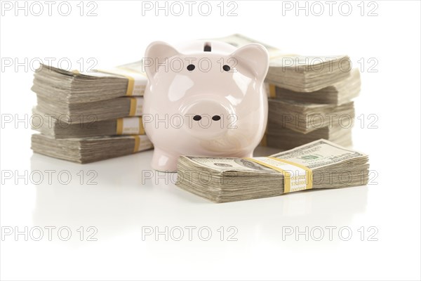 Pink piggy bank with stacks of hundreds of dollars isolated on a white background