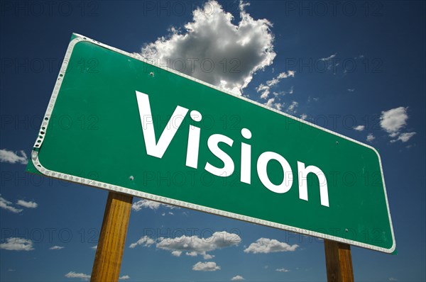 Vision green road sign with dramatic blue sky and clouds