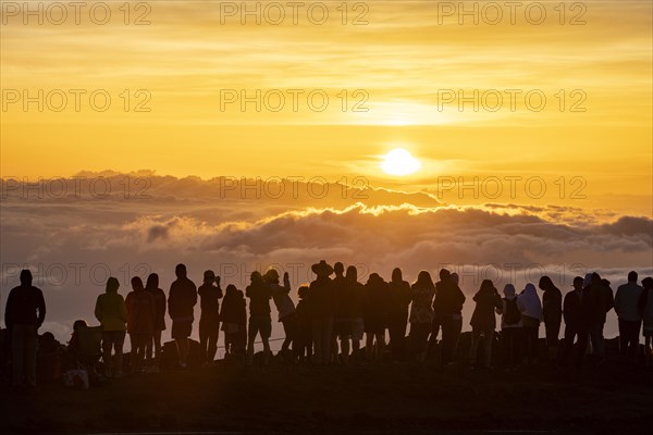 Touristen beobachten den Sonnenuntergang auf dem Gipfel des Haleakala Vulkan