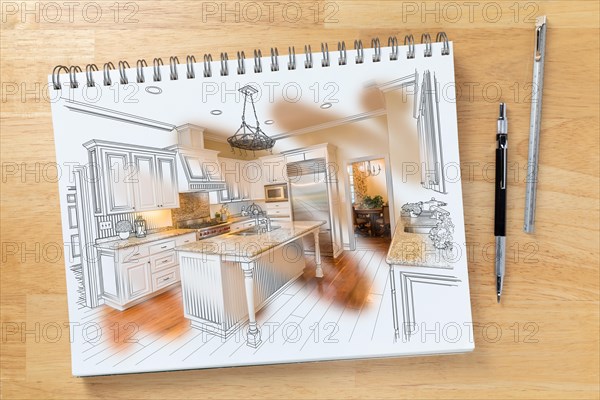 Sketch pad on desk with drawing of custom kitchen and brush stroke showing finished construction next to engineering pencil and ruler scale